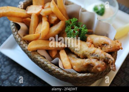 Pesce e patatine in primo piano su legno tavolo sfondo Foto Stock