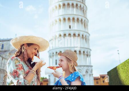 Buona famiglia alla moda con pizza vicino alla Torre Pendente a Pisa, Italia. Foto Stock