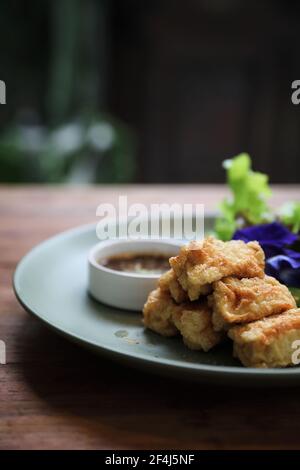 Cibo vegano tofu fritto giapponese su sfondo di legno stile vintage Foto Stock