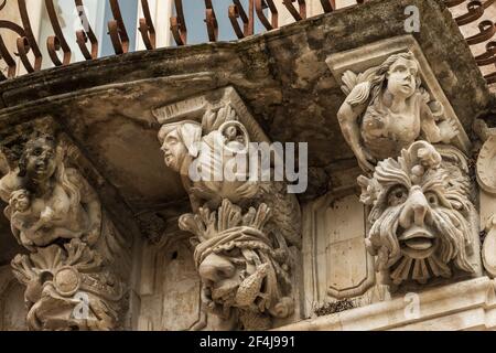 Bel mascaron barocco ornamento di un balcone nel centro storico di Ragusa, Sicilia Foto Stock