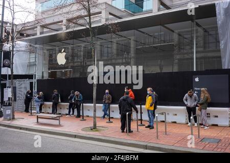 Gli acquirenti mascherati che avevano effettuato prenotazioni online si sono piazzati domenica 21 marzo 2021, al di fuori dell'Apple Store Pioneer Place, riaperto il 22 febbraio... Foto Stock