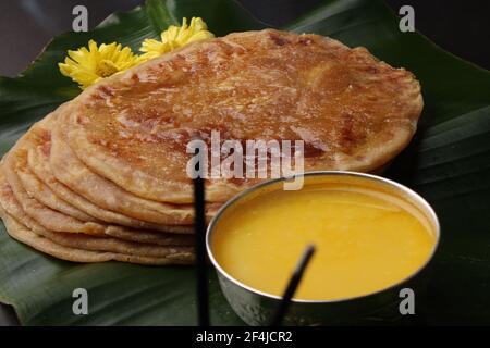 Puran poli, conosciuto anche come Holige, è un pane piatto dolce indiano dall'India consumato principalmente durante il festival di Holi. Servito su foglia di banana con ghee o puro Foto Stock