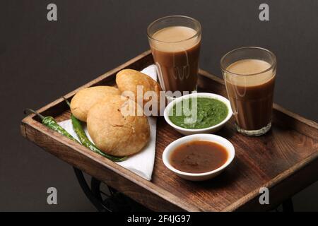 Kachouri cibo serpente indiano o kachoudi kachori servito con masala o tagliando il tamarindo di chai e chutney di menta Foto Stock