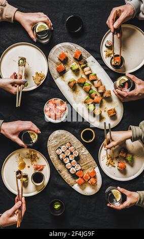 Piatto di persone che mangiano vari sushi durante la cena giapponese di blocco Foto Stock