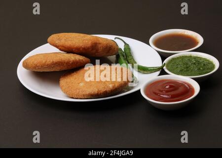 Kachouri cibo serpente indiano o kachoudi kachori servito con tamarindo e chutney di menta Foto Stock