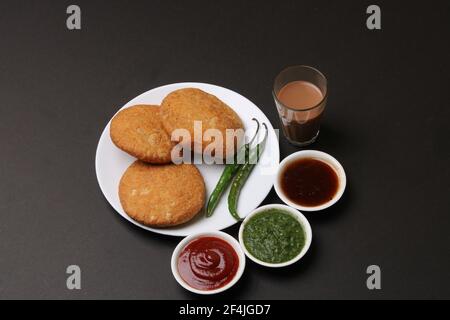 Kachouri cibo serpente indiano o kachoudi kachori servito con masala o tagliando il tamarindo di chai e chutney di menta Foto Stock