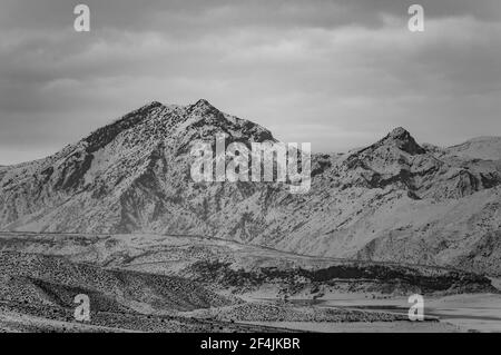 Foto in bianco e nero della catena montuosa di Yeranos in Armenia in una giornata invernale innevata Foto Stock