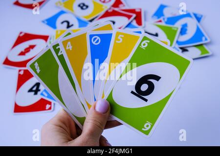 Kiev, Ucraina - 10.03.2021 carte da gioco uno in mano femminile. Giochi da tavolo. Passatempo. Giochi da tavolo. Soggiorno casa attività di svago per i bambini. Pandemia Foto Stock