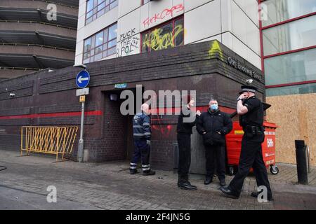 Un poliziotto (a destra) parla con un uomo (in cappello rosso) dopo aver affrontato i membri dei mezzi di comunicazione al di fuori della stazione di polizia di Bridewell a Bristol. I manifestanti hanno rotto le finestre e vandalizzato la stazione di polizia domenica dopo aver manifestato contro la poliziesca e poliziesca poliziesca controversa del governo. Data immagine: Lunedì 22 marzo 2021. Foto Stock