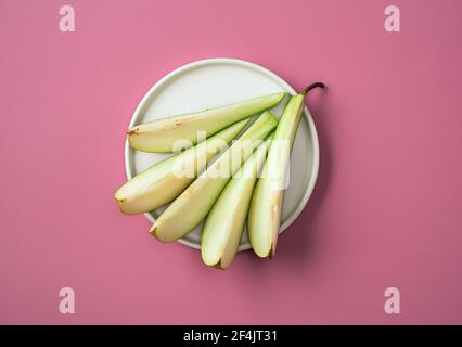 piatto di pera a fette su sfondo rosa, vista dall'alto Foto Stock