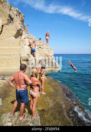 Isola di Favignana, Sicilia, Italia. Agosto 2019. Spiaggia di Bue Marino, persone che si rilassano in spiaggia e si tuffano in acqua Foto Stock