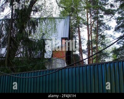 Casa abbandonata dietro una recinzione nei boschi, Russia Foto Stock