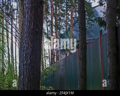 Casa abbandonata dietro una recinzione nei boschi, Russia Foto Stock