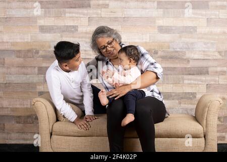 Momenti felici con la nonna, l'anziana signora indiana o asiatica che passa del tempo di qualità con i suoi grandi figli Foto Stock