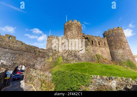 La strada cittadina attraverso le mura del castello a Conwy, Galles Foto Stock