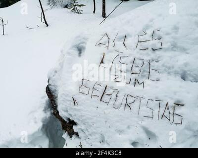Buon compleanno in tedesco con rami nella neve Foto Stock