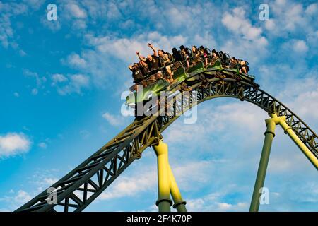 Persone che urlano e tengono le mani durante la corsa sulle montagne russe Helix Foto Stock