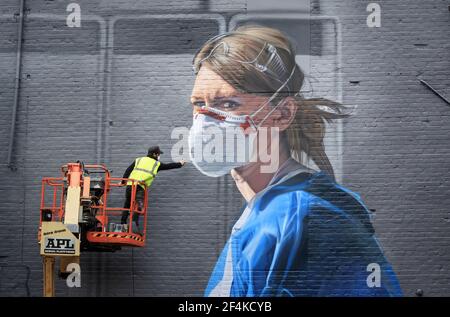 File foto datata 17/10/20 dell'artista Peter Barber che lavora su un murale nel centro di Manchester, raffigurante l'infermiera Melanie Senior, dopo che la National Portrait Gallery commissionò il murale sulla base di una fotografia di Johannah Churchill. Martedì ricorre il primo anniversario dell'annuncio del 23 marzo 2020 del primo blocco in tutta la Gran Bretagna. Data di emissione: Lunedì 22 marzo 2021. Foto Stock