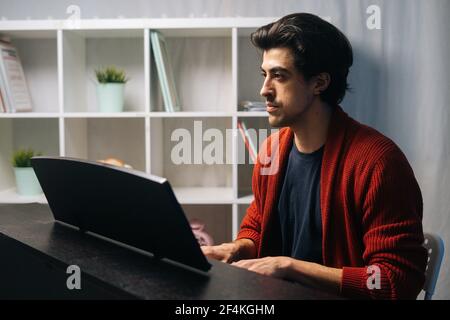 Giovane musicista di talento che suona il pianoforte in studio durante la lezione nel tempo libero. Foto Stock