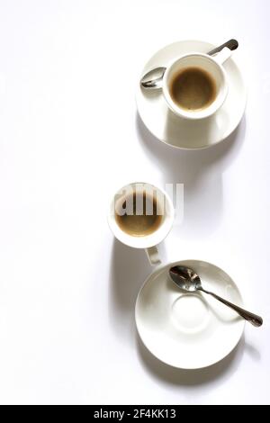 Due tazze di espresso su sfondo bianco. Vista dall'alto del caffè. Foto Stock