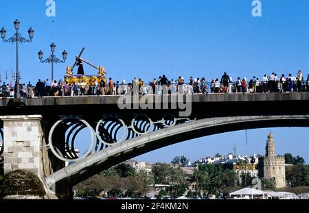 SPAGNA - la Vega (quartiere di Siviglia) - ANDALUSIA - Siviglia. semana santa, (viernes), Cofradía de 'la o' a la ida por el puente de Triana, torre del Oro Foto Stock