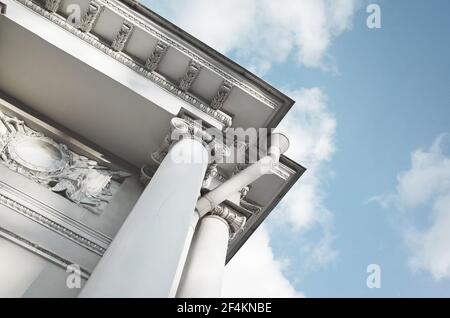 Angolo con colonne bianche di portico classico sotto il cielo nuvoloso in una giornata di sole. Esempio di architettura classica. San Pietroburgo, Russia Foto Stock