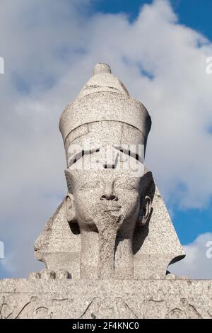 Statua di sfinge di granito. Antico monumento egiziano sotto sfondo blu cielo nuvoloso. Punto di riferimento pubblico montato sulla costa del fiume Neva a San Pietroburgo, Russ Foto Stock