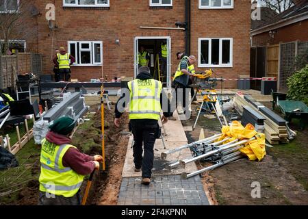 Volontari della band benefica dei costruttori al lavoro nel giardino della casa di Rob Lamb a Solihull, West Midlands. Il 58-year-old è stato lasciato paralizzato dopo una caduta quando si è svenuto a causa della pressione sanguigna bassa a casa in ottobre. Data immagine: Mercoledì 17 marzo 2021. Foto Stock