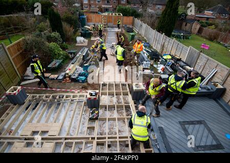 Volontari della band benefica dei costruttori al lavoro nel giardino della casa di Rob Lamb a Solihull, West Midlands. Il 58-year-old è stato lasciato paralizzato dopo una caduta quando si è svenuto a causa della pressione sanguigna bassa a casa in ottobre. Data immagine: Mercoledì 17 marzo 2021. Foto Stock