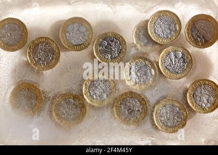 Fotografia di monete da £1 in un blocco di ghiaccio. Foto Stock