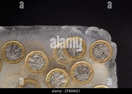 Fotografia di monete da £1 in un blocco di ghiaccio. Foto Stock