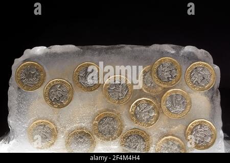 Fotografia di monete da £1 in un blocco di ghiaccio. Foto Stock