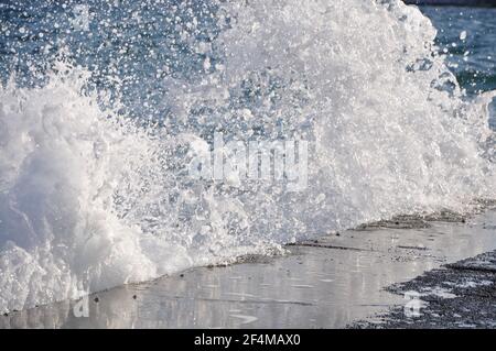 Onde con spruzzi sulla costa rocciosa. Onde che si infrangono su una costa rocciosa della costa del Golfo. Foto Stock