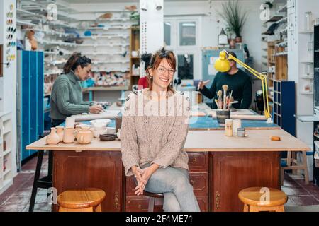 Stock foto di successo donna proprietario di ceramica accademia sorridente e guardando la fotocamera. Foto Stock