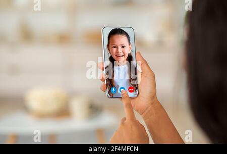 Madre che parla con sua figlia tramite videochiamata sullo smartphone Foto Stock