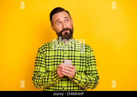 Ritratto di un uomo attraente che usa il gadget del dispositivo per la creazione di post commento isolato su sfondo giallo brillante Foto Stock