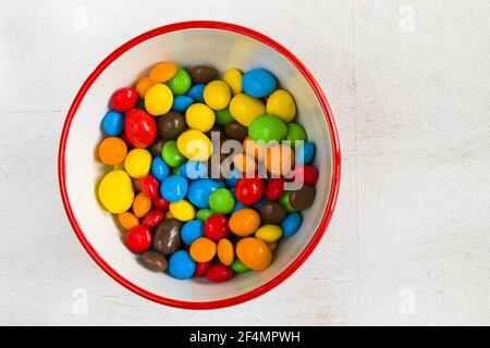 Caramelle al cioccolato nella ciotola su sfondo bianco Foto Stock