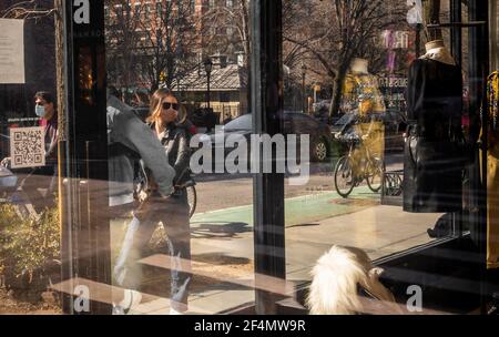 New York, Stati Uniti. 21 Mar 2021. I newyorkesi mascherati e i visitatori passano davanti a una vetrina su Bleecker Street mentre approfittano del caldo clima di Greenwich Village a New York durante la pandemia COVID-19 di domenica 21 marzo 2021. (ÂPhoto di Richard B. Levine) Credit: Sipa USA/Alamy Live News Foto Stock