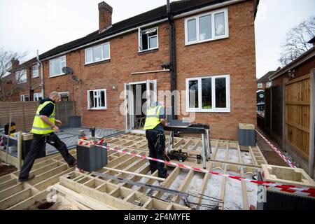 Volontari della band benefica dei costruttori al lavoro nel giardino della casa di Rob Lamb a Solihull, West Midlands. Il 58-year-old è stato lasciato paralizzato dopo una caduta quando si è svenuto a causa della pressione sanguigna bassa a casa in ottobre. Data immagine: Mercoledì 17 marzo 2021. Foto Stock