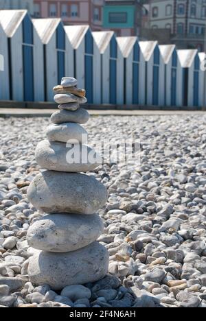 Case di legno blu e bianco. Cabine sulla spiaggia di Yport, con una torre in pietra Foto Stock