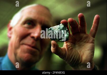 Dr. Bob Symes Dicembre 1999 presso l'azienda del museo di storia nazionale Un cristallo di Symesute all'interno di un pezzo di mendipite in la galleria dei minerali Foto Stock