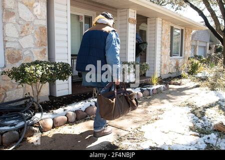 Austin, Texas USA 20 febbraio 2021: I veterani senza tetto arrivano per la prima notte in una casa sobria a conduzione privata dopo aver trascorso una settimana in un rifugio riscaldato a gestione di chiesa durante il recente grave clima invernale di Austin. I membri della Chiesa hanno organizzato le nuove sistemazioni dopo che entrambi gli uomini hanno chiesto aiuto per il loro alcolismo. Foto Stock