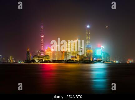 Shanghai Skyline di notte con luna e nebbia nel Aria - lunga esposizione sul fiume Huangpu