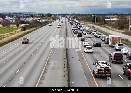 Confronto tra i pendolari in direzione nord nella zona di traffico serale e. Il traffico in accelerazione sulle corsie opposte dell'Interstate 5 Vicino a Everett Foto Stock