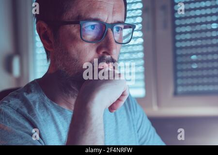 Uomo che indossa occhiali da vista con luce blu che blocca lo schermo del computer, primo piano ritratto con messa a fuoco selettiva Foto Stock