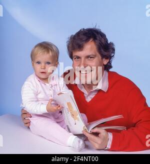 Padre Reading alla figlia in studio Shoot, Winkfield Berkshire, Inghilterra, Regno Unito Foto Stock