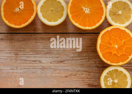 Arance, lime e limoni scivoli su tavola di legno vista da sopra.Beautiful Sfondo con frutta fresca metà cut.Healthy mangiare vitamina C.Summer tropic Foto Stock