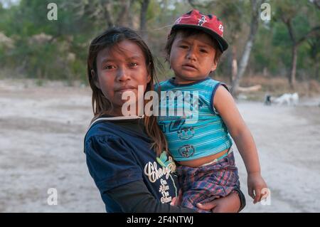 Chaco. Argentino. 15-01-2019. Ragazza indigena che porta il suo piccolo fratello con le braccia nella provincia di Chaco, nel nord dell'Argentina. Foto Stock