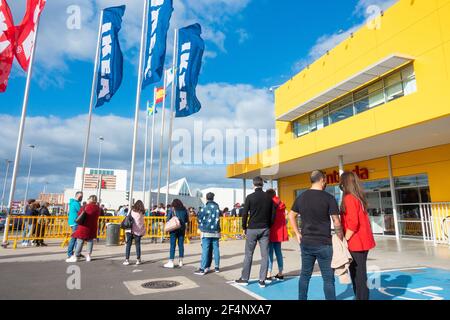 Persone che indossano maschere facciali, coperture coda fuori negozio Ikea in Spagna durante Covid, pandemia di Coronavirus. Foto Stock