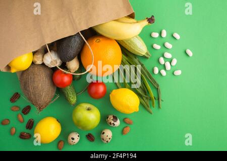 Sacchetto di carta di verdure e frutta su sfondo verde. Concetto di cibo in sacchetto. Vista dall'alto.Copia spazio. Foto Stock